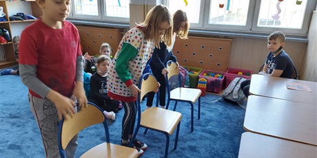 Powiększ grafikę: Uczniowie jak najprędzej i jak najciszej dobiegają do stolików i odsuwają i przysuwają krzesła.