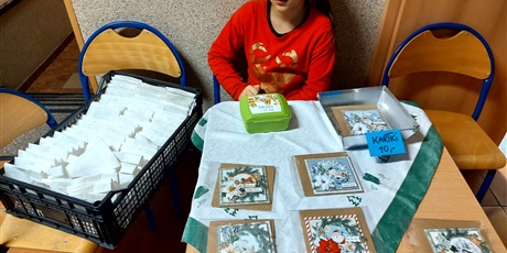 Powiększ grafikę: Dziewczynka sprzedająca karty świąteczne oraz pierniki.